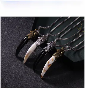 Detail of wolf tooth pendants in black and marble finishes with antique metal caps