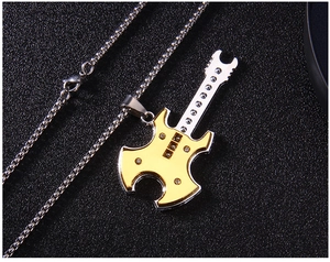 Gros plan du pendentif guitare bicolore or et argent avec des strass et une chaîne en métal