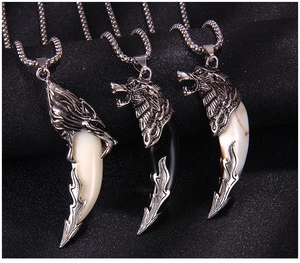 Detailed view of wolf head tooth pendants in silver, ivory, and marble finishes