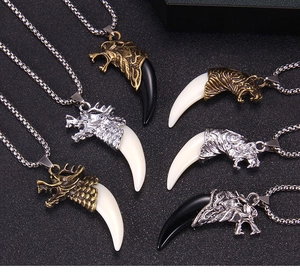 Détail de colliers dent de loup vintage avec pendentifs tête de dragon et de tigre