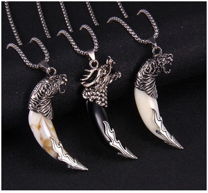 Detail of dragon and tiger head steel necklaces with bone-textured wolf tooth pendants