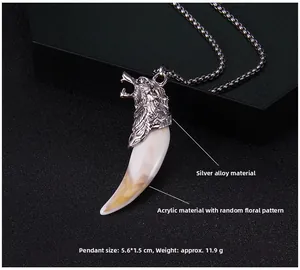 Detail view of silver wolf head pendant with faux fang on black jewelry box