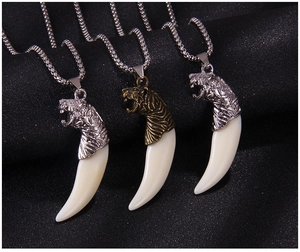 Détails des pendentifs en forme de dent de loup en argent et bronze sur fond noir