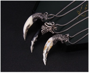 Detailed close-up of retro wolf tooth pendants with animal head carvings on black background