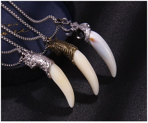 Détail macro de pendentifs dent de loup avec motifs d'animaux sur des chaînes en acier