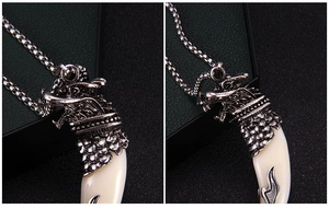 Detailed close-up of retro stainless steel dragon head pendant with white tusk detail