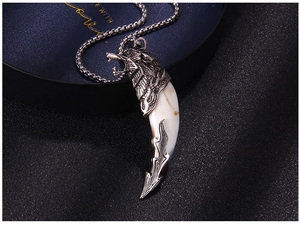 Macro shot of retro silver metal wolf head pendant with resin fang on a beaded chain