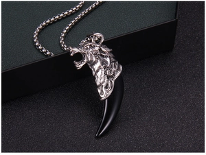 Gros plan du pendentif tête de dragon avec dent de loup noire sur boîte à bijoux