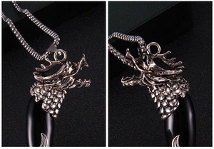 Macro detail of retro dragon head pendant with black polished fang and vintage box chain