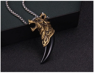 Détail macro du pendentif tête de loup vintage avec dent noire sur une chaîne en acier