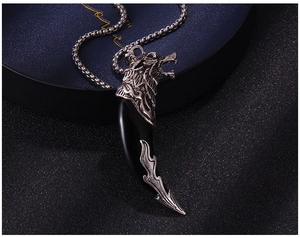 Close-up of vintage silver wolf tooth pendant with black resin on a blue jewelry box