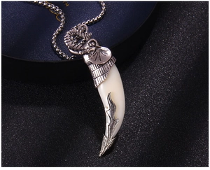Close-up of vintage elephant pendant with white resin tooth and stainless steel ball chain