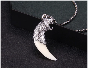 Détail de la tête de dragon sur pendentif dent de loup avec chaîne en maille miroir