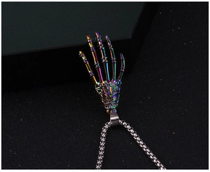 Macro detail of rainbow plated skeleton hand pendant with vibrant metallic luster