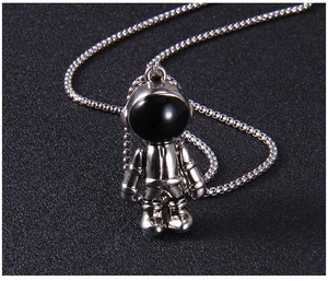 Vue macro détaillée d'un pendentif astronaute en argent poli avec une visière noire brillante