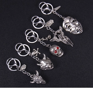 Five gothic silver metal keychains featuring skull, mask and devil charms on black fabric