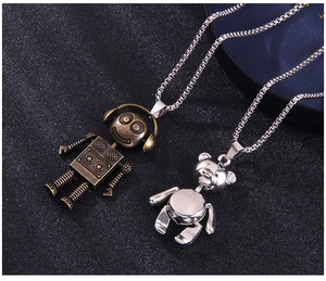 Détails macro des pendentifs robot en bronze et ours en argent sur chaînes punk