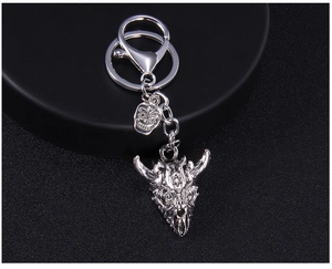 Detail of vintage silver bull skull keychain with engraved star and punk skull charm