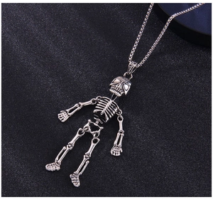 Détail du pendentif squelette punk argenté avec articulations mobiles sur chaîne box