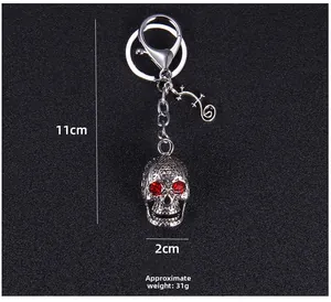 Punk skeleton keychain with red rhinestone eyes and gecko pendant, weighing about 31g