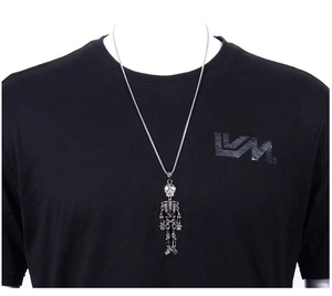 Gros plan détaillé d'un collier pendentif squelette punk argenté sur un t-shirt noir