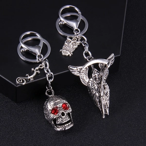 Punk style skull and grim reaper keychains with red rhinestones in vintage silver finish
