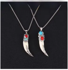 Détail de pendentifs dent de loup tribaux avec incrustations de turquoise et chaîne vintage