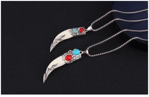 Détail de pendentifs dent de loup vintage avec gravures ethniques et perles