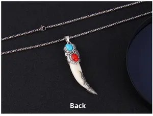 Vue arrière du pendentif dent de loup ethnique avec pierres rouges et bleues sur chaîne