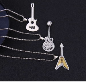 Detailed view of three stainless steel guitar pendants with intricate musical engravings