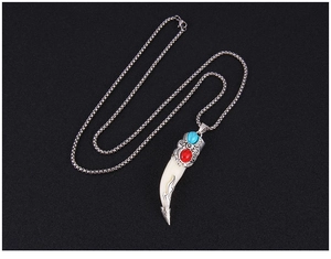 Détail du pendentif dent de loup tribal rétro avec pierres bleues et rouges sur chaîne