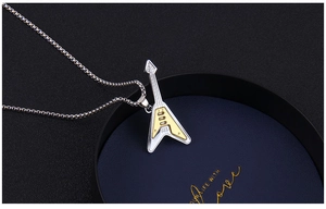 Macro detail of V-shaped electric guitar pendant with silver and gold two-tone finish