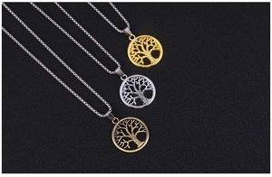 Detail of tree of life pendants in gold, silver and bronze finishes with hollow carvings