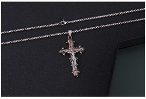 Détail d'un pendentif crucifix vintage en acier avec gravure INRI sur une chaîne box