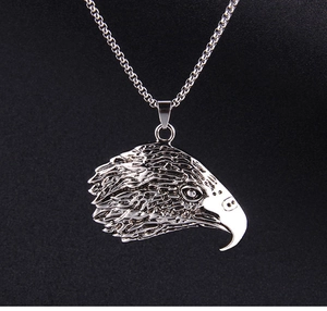 Vue détaillée du pendentif tête d'aigle avec plumes ciselées sur une chaîne en acier