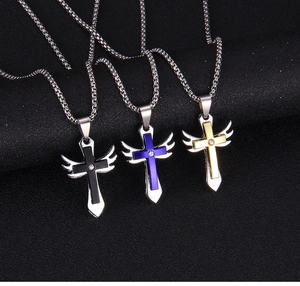 Détail de pendentifs croix ailée avec cristal en finitions noir bleu et or