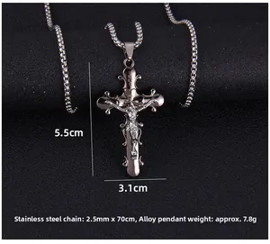 Vue macro du pendentif croix vintage avec gravure INRI sur une chaîne à billes en acier