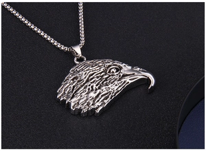 Vue macro d'un pendentif tête d'aigle argenté avec plumes détaillées et chaîne