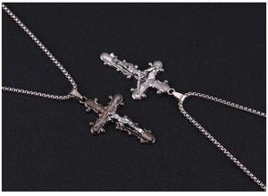 Détail de pendentifs croix en argent et noir avec gravure INRI sur chaînes vénitiennes