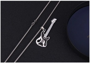 Close-up of a vintage electric guitar pendant necklace on a black leather background