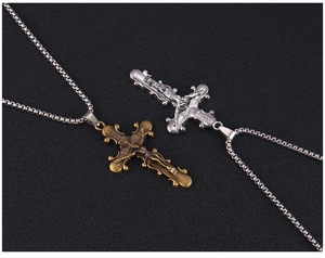 Détail de pendentifs crucifix vintage en bronze et argent sur chaînes à mailles