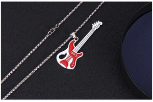Macro shot of guitar pendant with red and white enamel on a silver link chain necklace