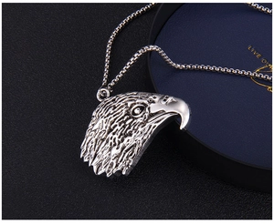 Détail macro du pendentif tête d'aigle rétro en acier inoxydable avec textures de plumes