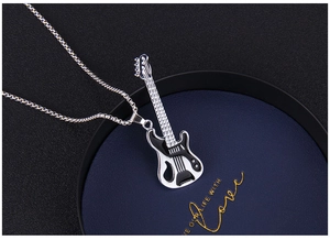 Detailed close-up of a guitar pendant with black enamel finish on a woven steel chain