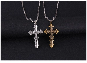 Détails macro des colliers crucifix INRI en argent et bronze sur fond noir texturé