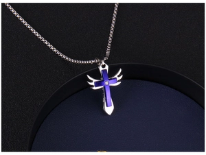 Détail d'un collier croix bleue avec des ailes d'ange argentées et une pierre précieuse