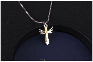 Détail du pendentif croix avec ailes d'ange et zircon dans un écrin à bijoux bleu