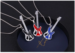 Detailed view of three guitar-shaped necklaces in black, red, and blue enamel inside a box