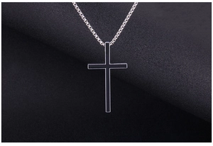 Macro close-up of retro stainless steel cross pendant with black enamel inlay detail