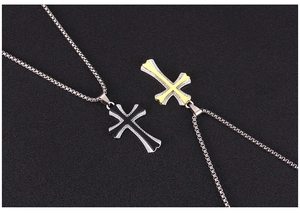 Dettaglio macro di ciondoli a croce con strass scintillanti e catena a maglie quadrate